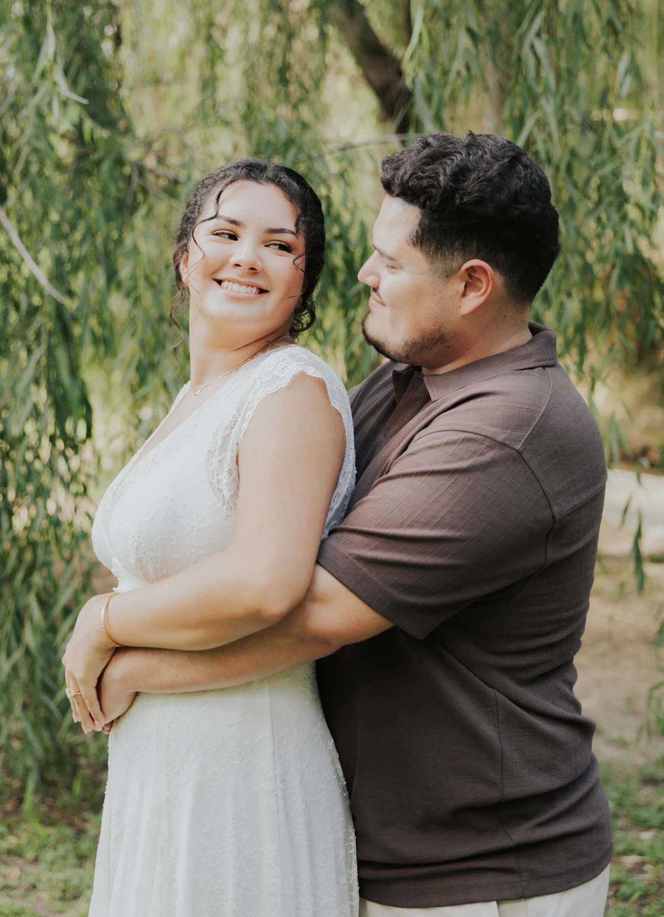 Karen smiling as Pablo holds her beneath the willow tree